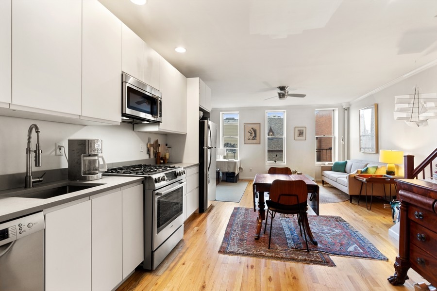 65 Bond Street, Unit 4 Brooklyn, NY 11217 - Photo 3 of 7 a kitchen with stainless steel appliances granite countertop a stove top oven a sink dishwasher and white cabinets with wooden floor