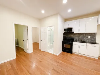a view of a kitchen with a refrigerator and a stove top oven