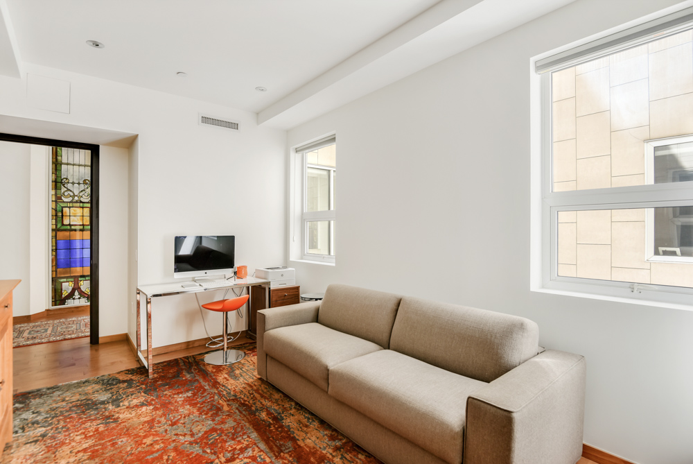 135 West 4th Street, Unit 3E Manhattan, NY 10012 - Photo 9 of 11 a living room with furniture and a flat screen tv
