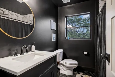 a bathroom with a toilet a sink and mirror