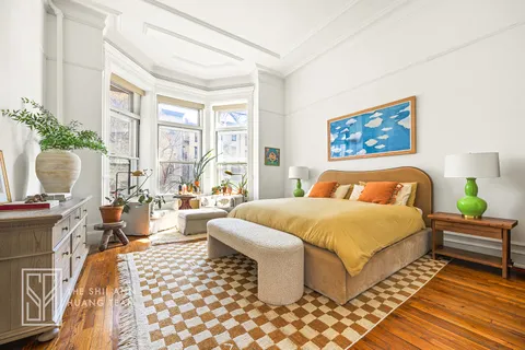 a bedroom with a large bed couch and a window