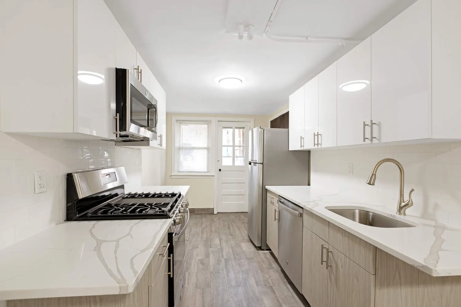 a kitchen with a sink a stove cabinets and a wooden floor