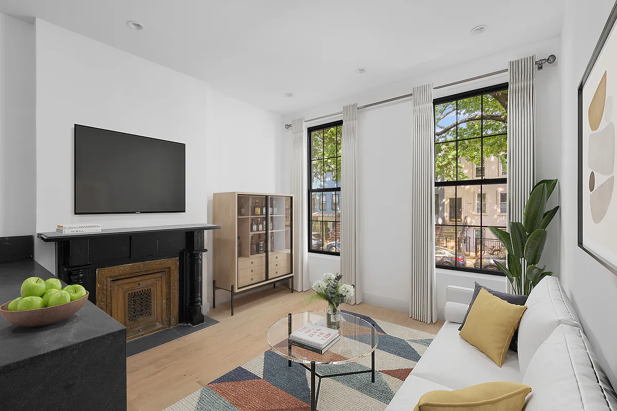 1242 Putnam Avenue, Unit 2 Brooklyn, NY 11221 - Photo 4 of 8 a living room with furniture a fireplace and a flat screen tv