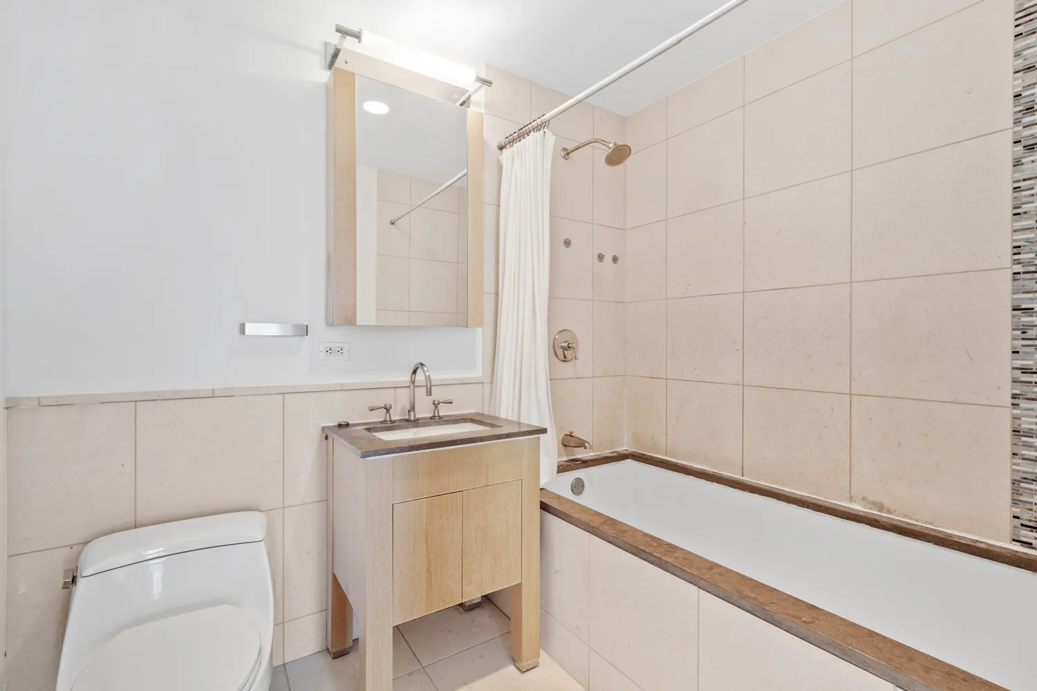 a bathroom with a granite countertop sink a toilet and shower