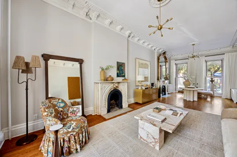 a living room with furniture a fireplace and a chandelier