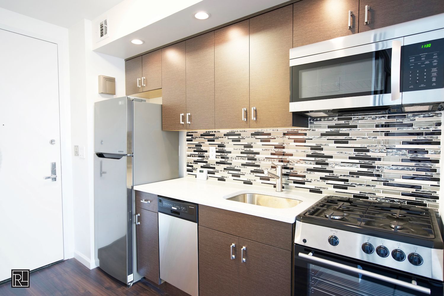 300 East 62nd Street, Unit 1405 Manhattan, NY 10065 - Photo 7 of 10 a kitchen with stainless steel appliances granite countertop a stove and a refrigerator
