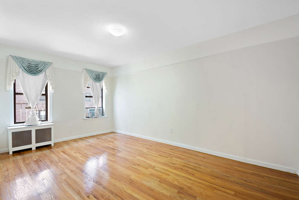 779 Riverside Drive, Unit A50 Manhattan, NY 10032 - Photo 6 of 14 an empty room with wooden floor and windows