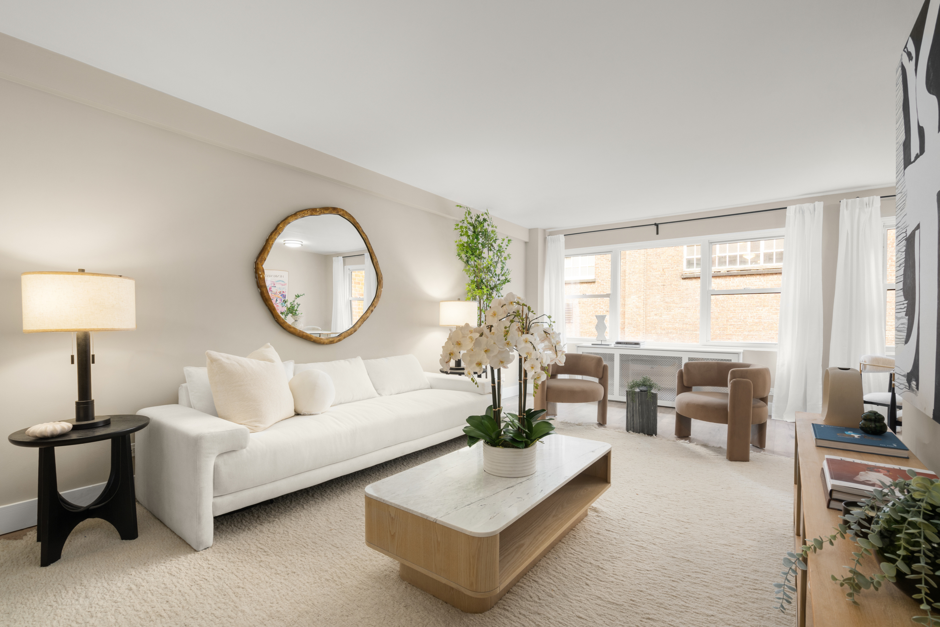 347 East 53rd Street, Unit 2C Manhattan, NY 10022 - Photo 6 of 18 a living room with furniture a large mirror and a large window