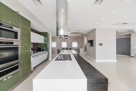 a large white kitchen with granite countertop a stove a sink and a refrigerator