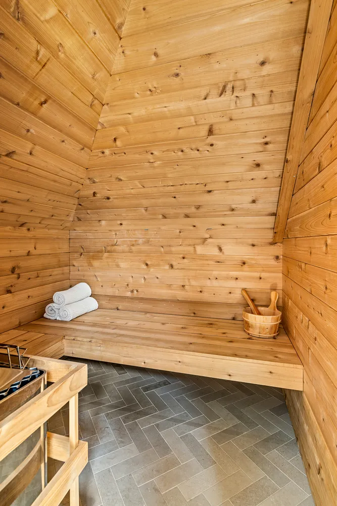 a view of a brick house with a small yard and a large tree