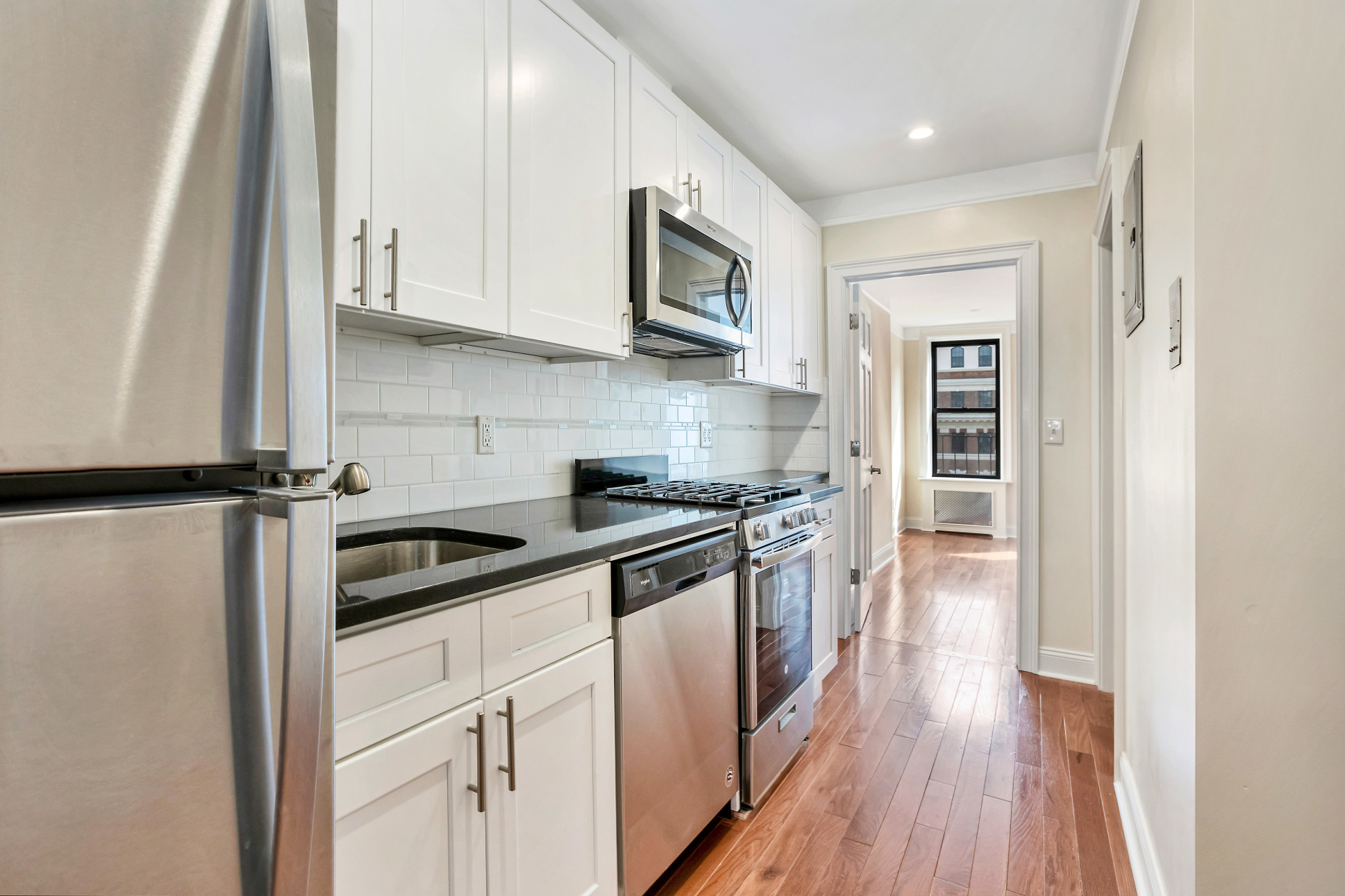 314 East 83rd Street, Unit 5W Manhattan, NY 10028 - Photo 2 of 4 a kitchen with stainless steel appliances granite countertop a stove a sink and a refrigerator