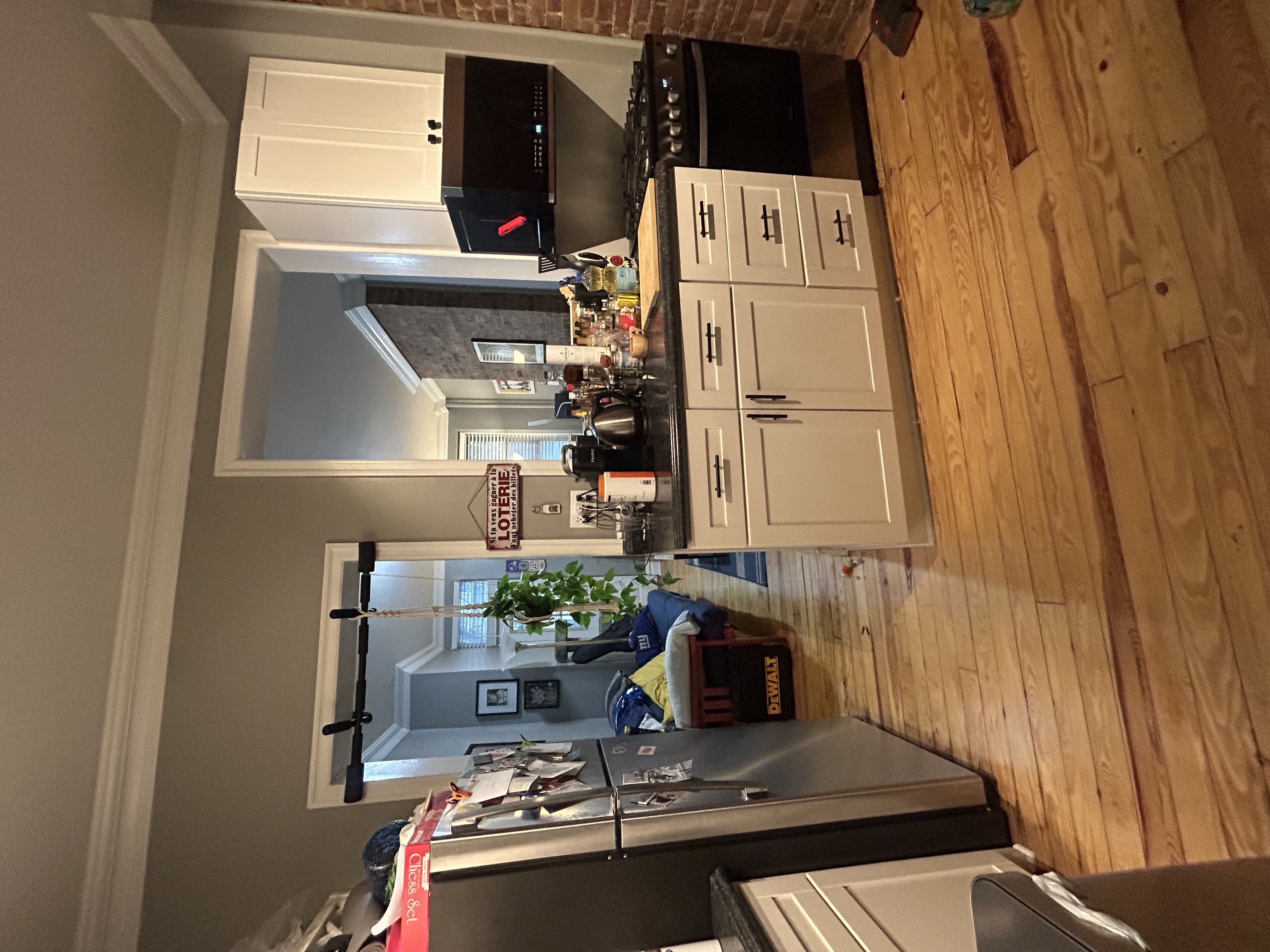 317 East 73rd Street, Unit 1RE Manhattan, NY 10021 - Photo 5 of 9 a kitchen with stainless steel appliances white cabinets and wooden floor