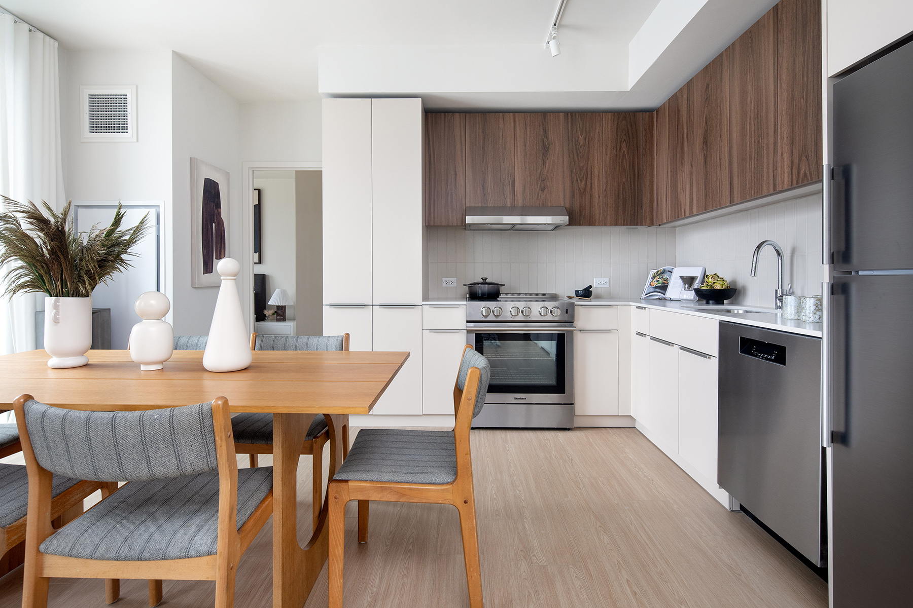 30-77 Vernon Boulevard, Unit PH811W Queens, NY 11102 - Photo 3 of 21 a kitchen with a table chairs sink and cabinets