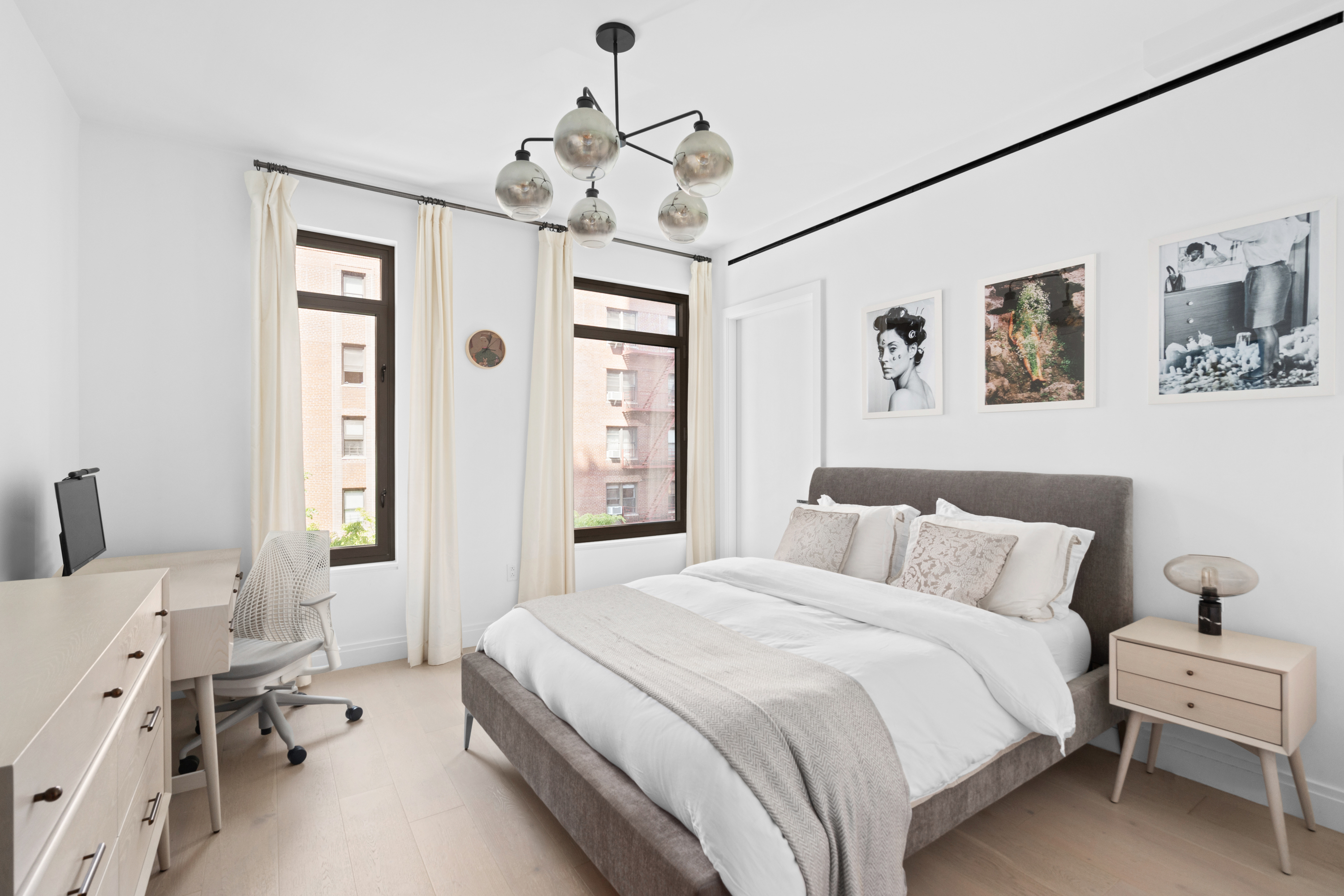 212 West 95th Street, Unit 4A Manhattan, NY 10025 - Photo 4 of 12 a bedroom with a bed and a chandelier