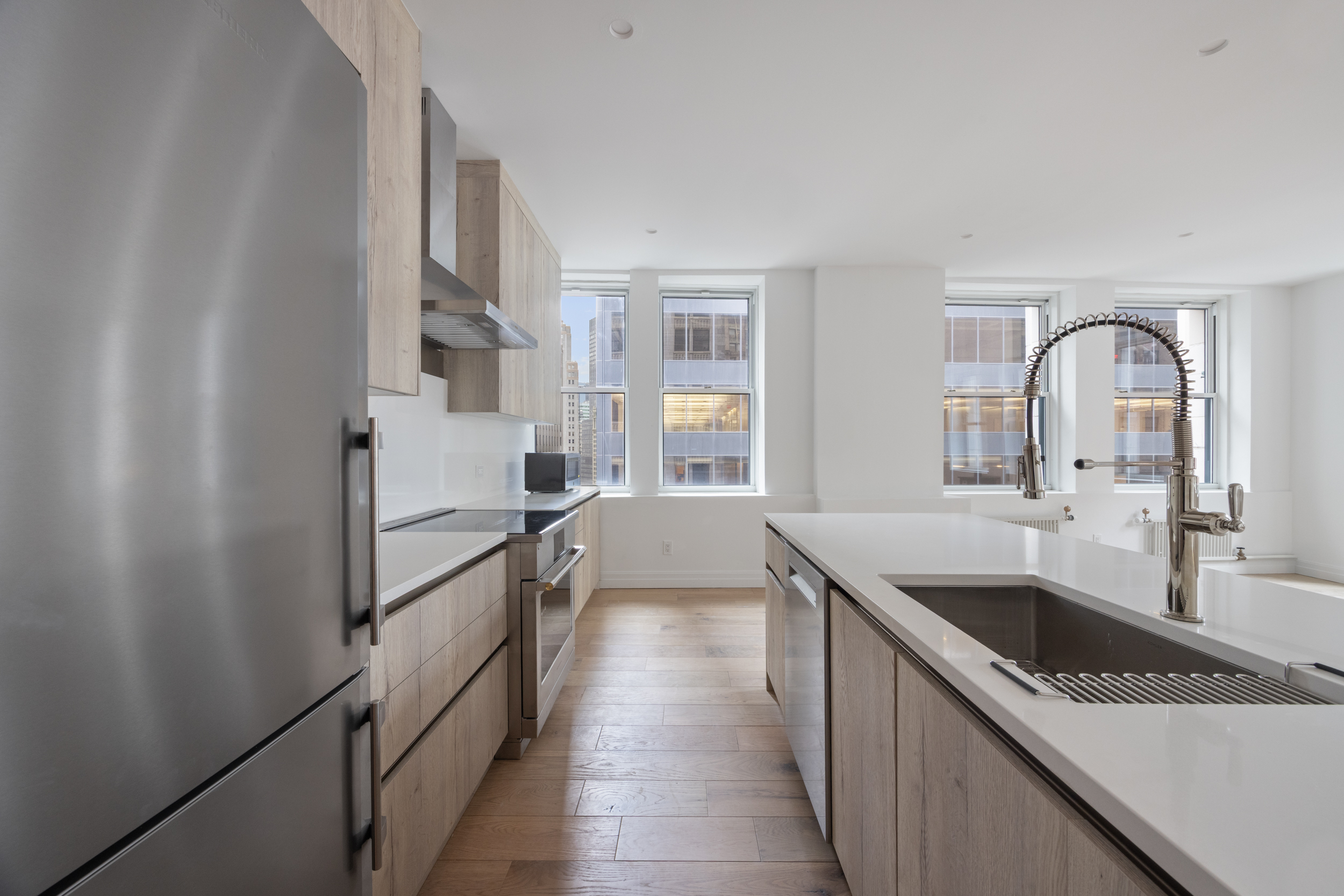 55 Liberty Street, Unit 12C Manhattan, NY 10005 - Photo 5 of 10 a kitchen with granite countertop a sink and cabinets
