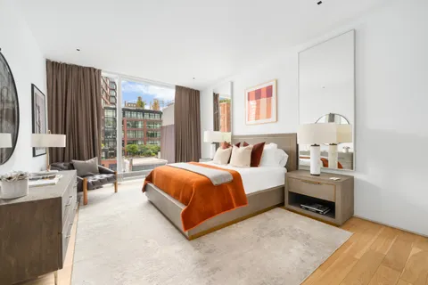 a spacious bedroom with a bed and a large window