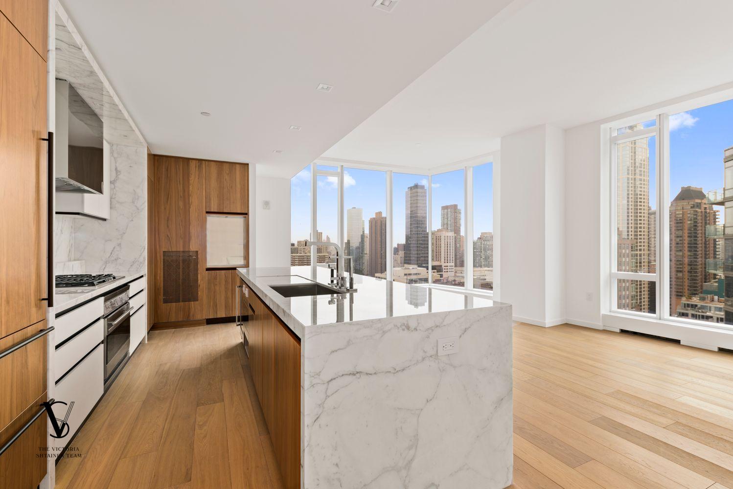 1 West End Avenue, Unit 28C Manhattan, NY 10023 - Photo 3 of 26 a large living room with stainless steel appliances kitchen island granite countertop a large window and a kitchen view