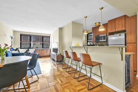 a dining hall with stainless steel appliances a dining table and chairs with wooden floor