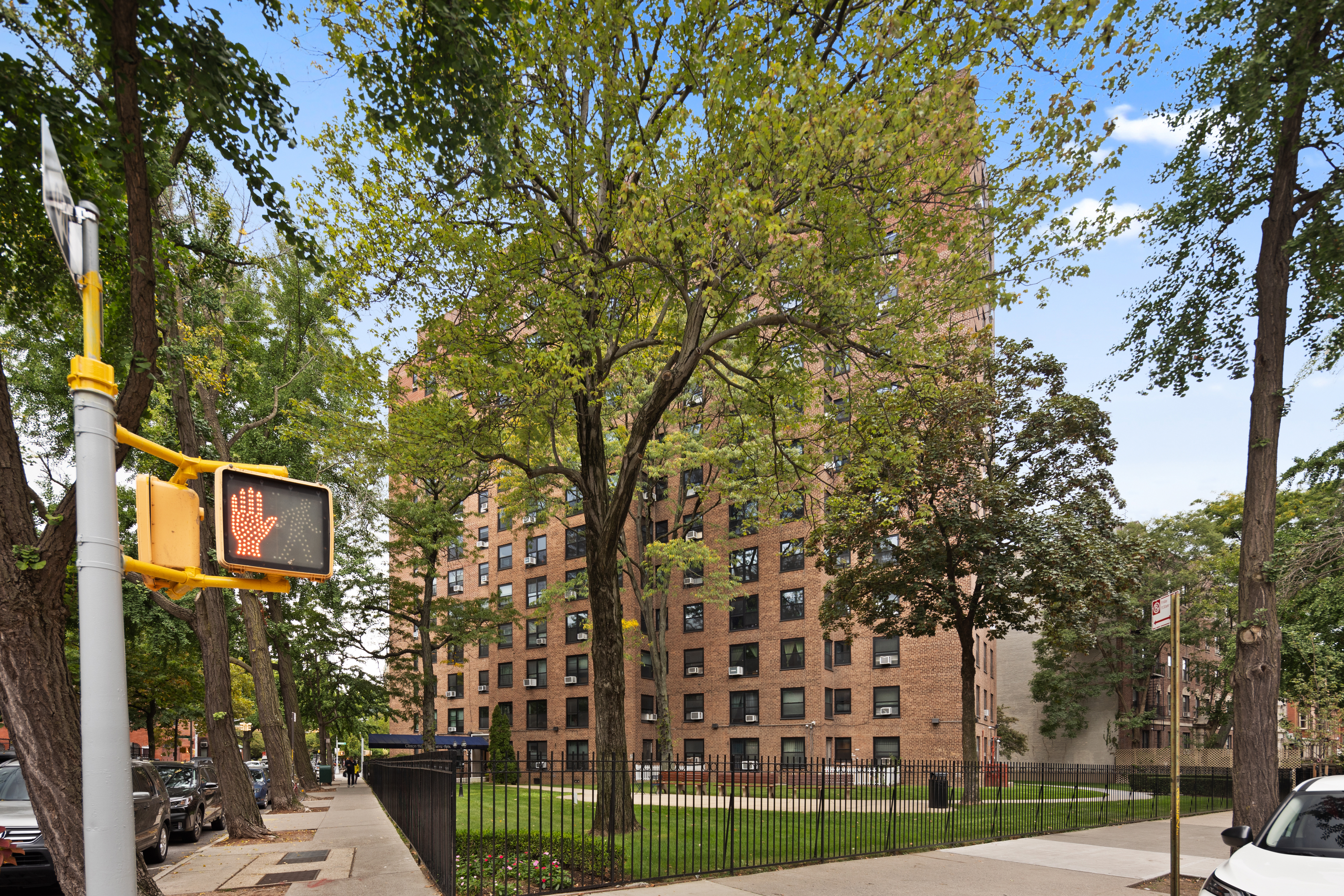 210 Clinton Avenue, Unit 4B Brooklyn, NY 11205 - Photo 6 of 8 a street sign on a tree in front of a building