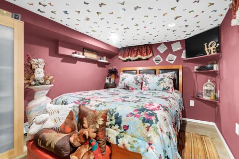 a bedroom with a bed and a painting on the wall