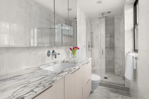 a bathroom with a granite countertop sink a toilet and shower
