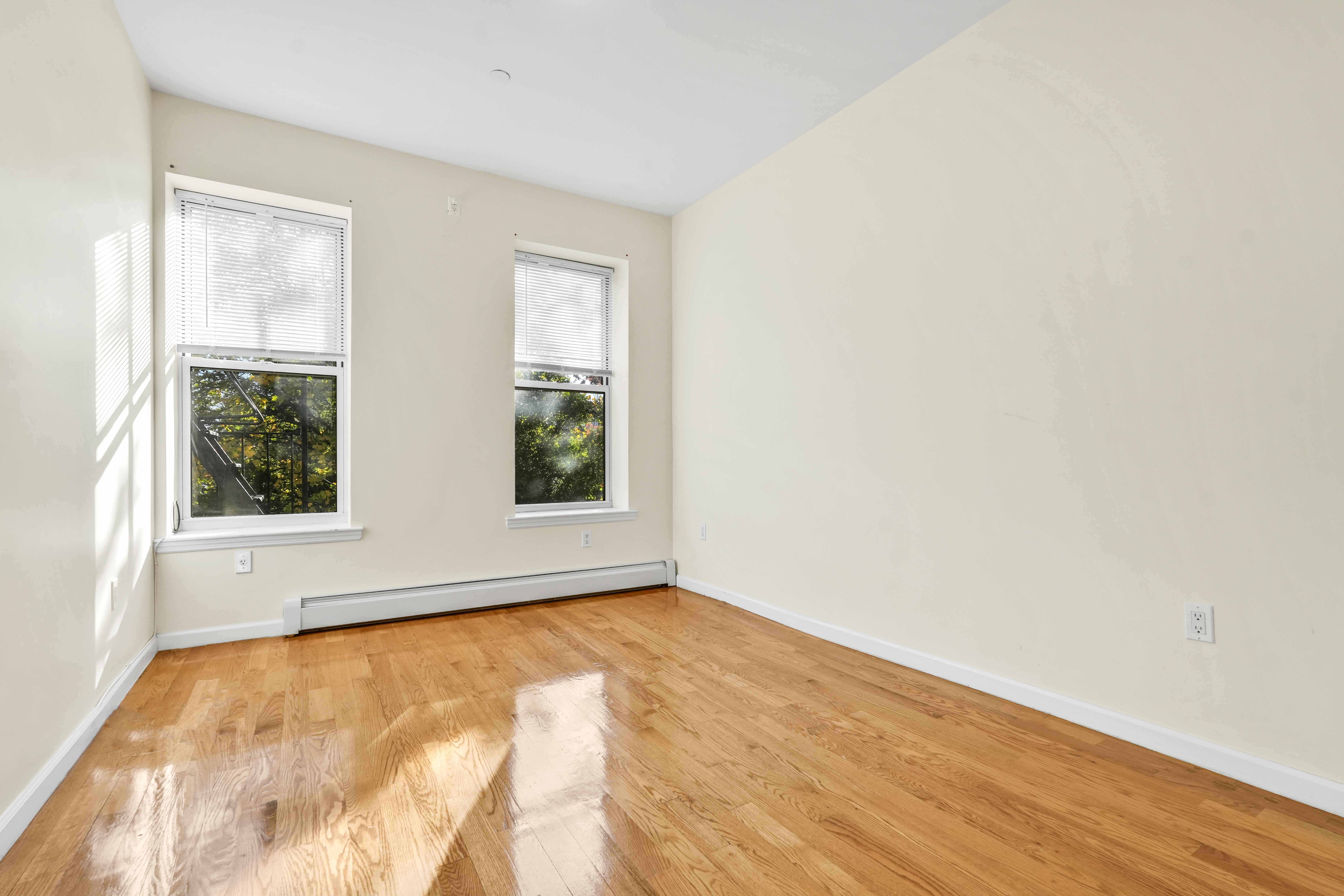 1892 Bergen Street, Unit 2 Brooklyn, NY 11233 - Photo 7 of 24 a view of an empty room with wooden floor and a window