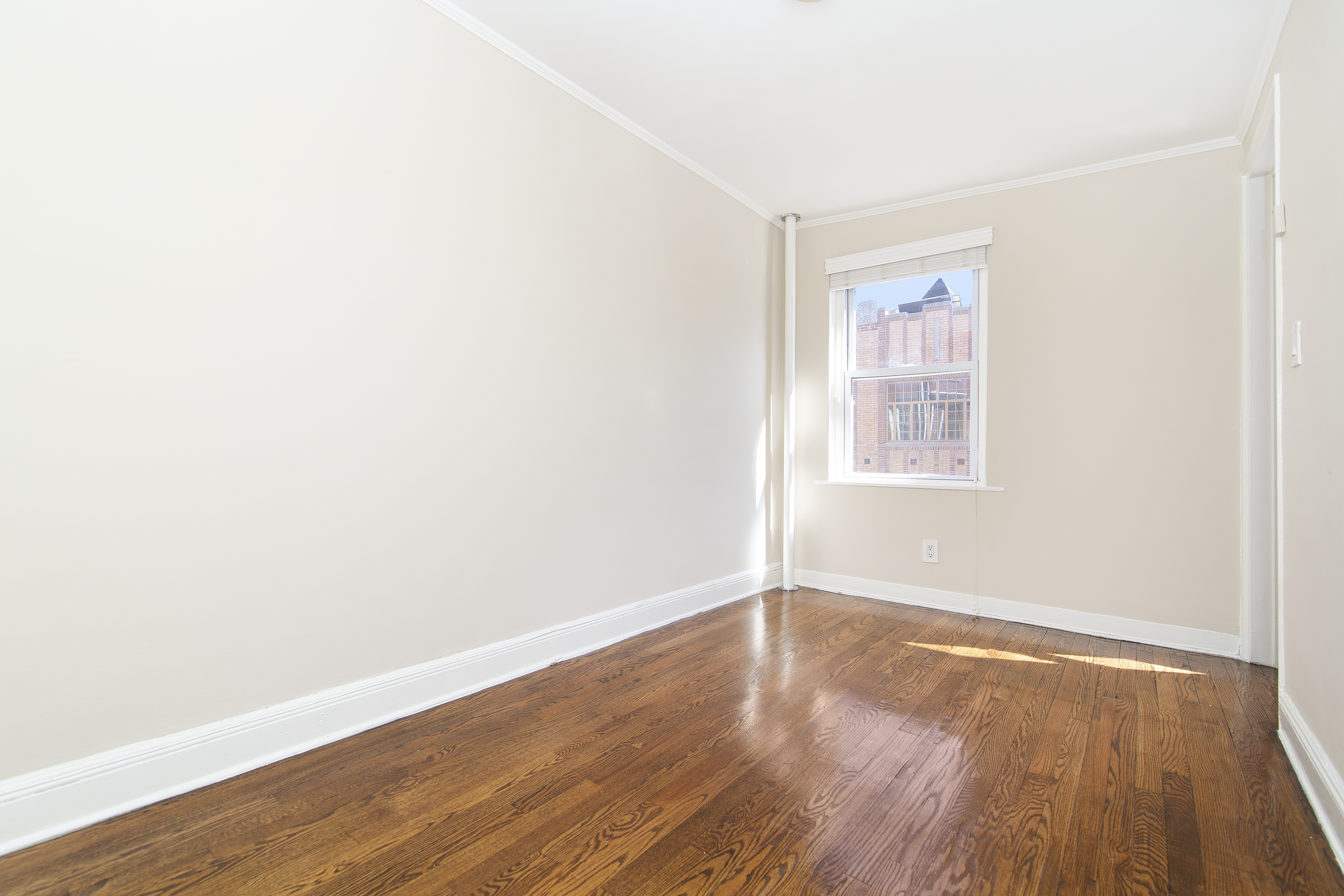 304 Bleecker Street, Unit 3F Manhattan, NY 10014 - Photo 4 of 6 an empty room with wooden floor and windows