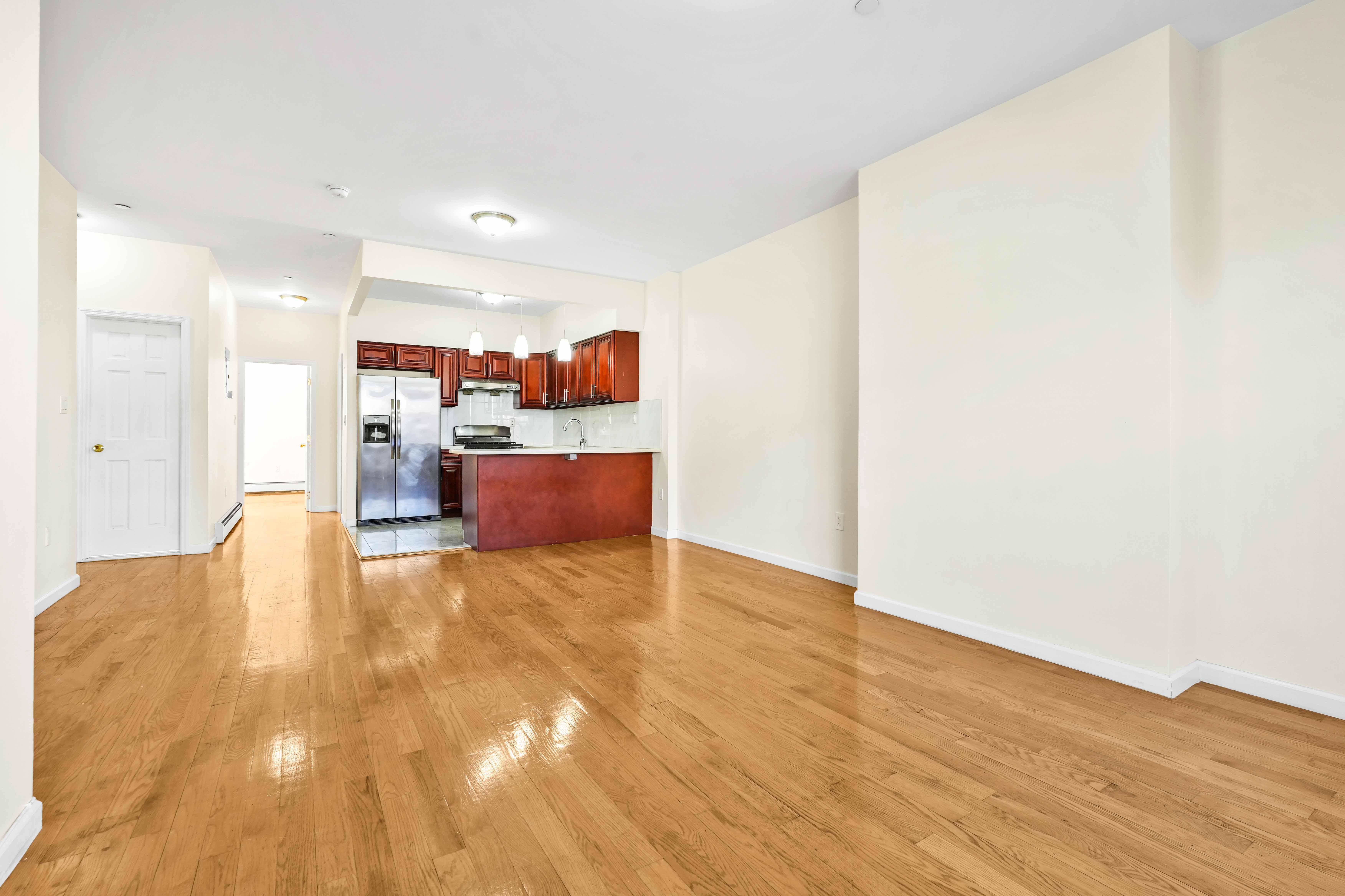1892 Bergen Street, Unit 2 Brooklyn, NY 11233 - Photo 20 of 24 a view of kitchen with kitchen island a sink wooden floor and a living room view