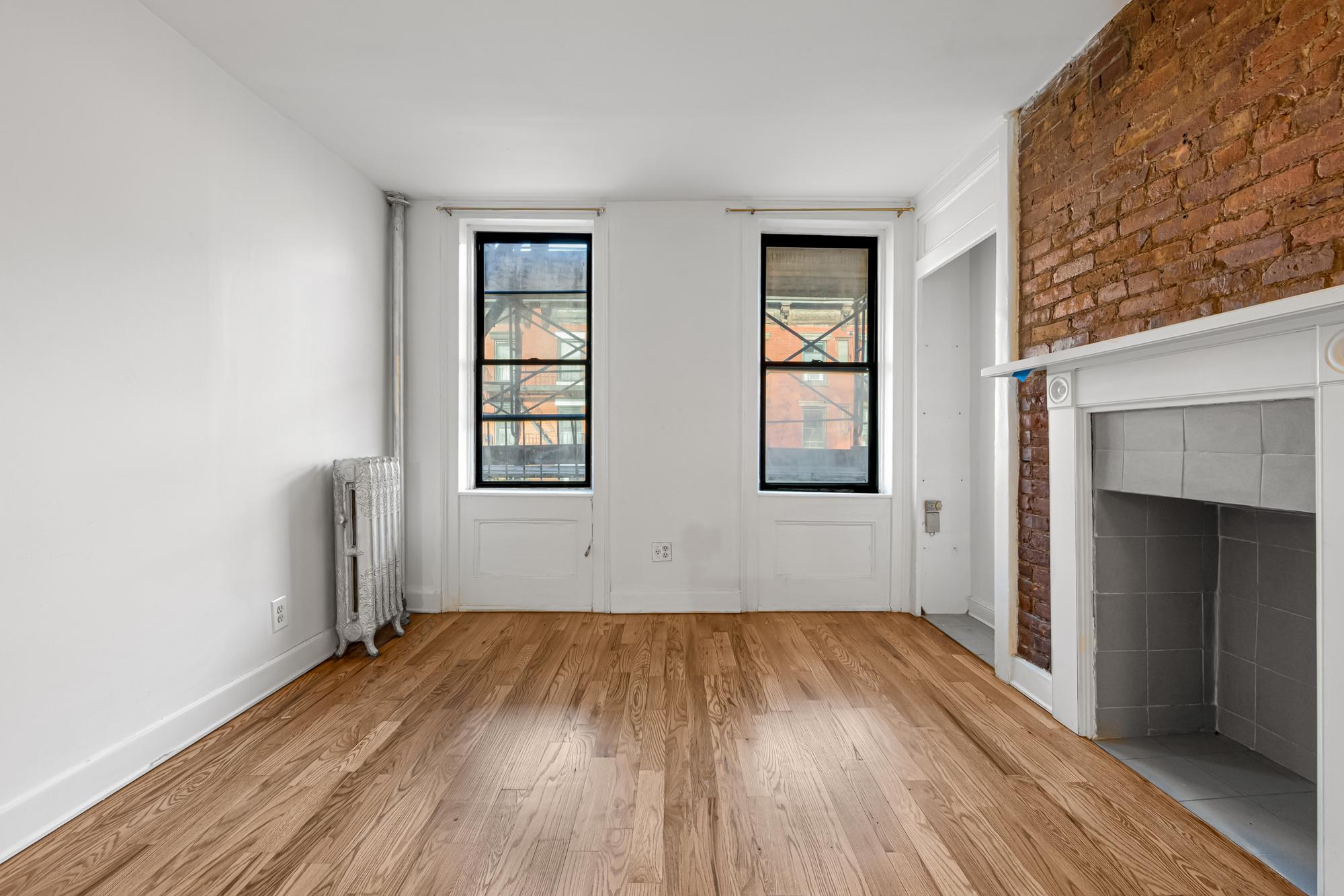 504 East 6th Street, Unit 6 Manhattan, NY 10009 - Photo 18 of 19 an empty room with wooden floor and windows