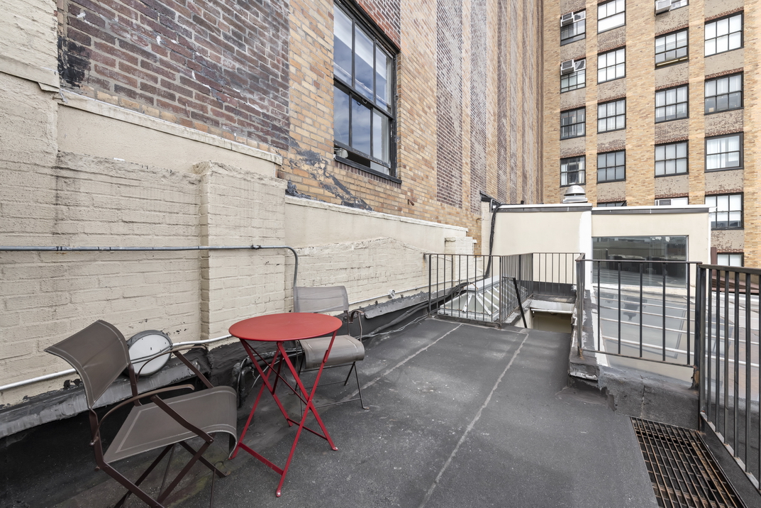 405 Broadway, Unit PH Manhattan, NY 10013 - Photo 16 of 17 a view of a patio with a table and chairs and a barbeque