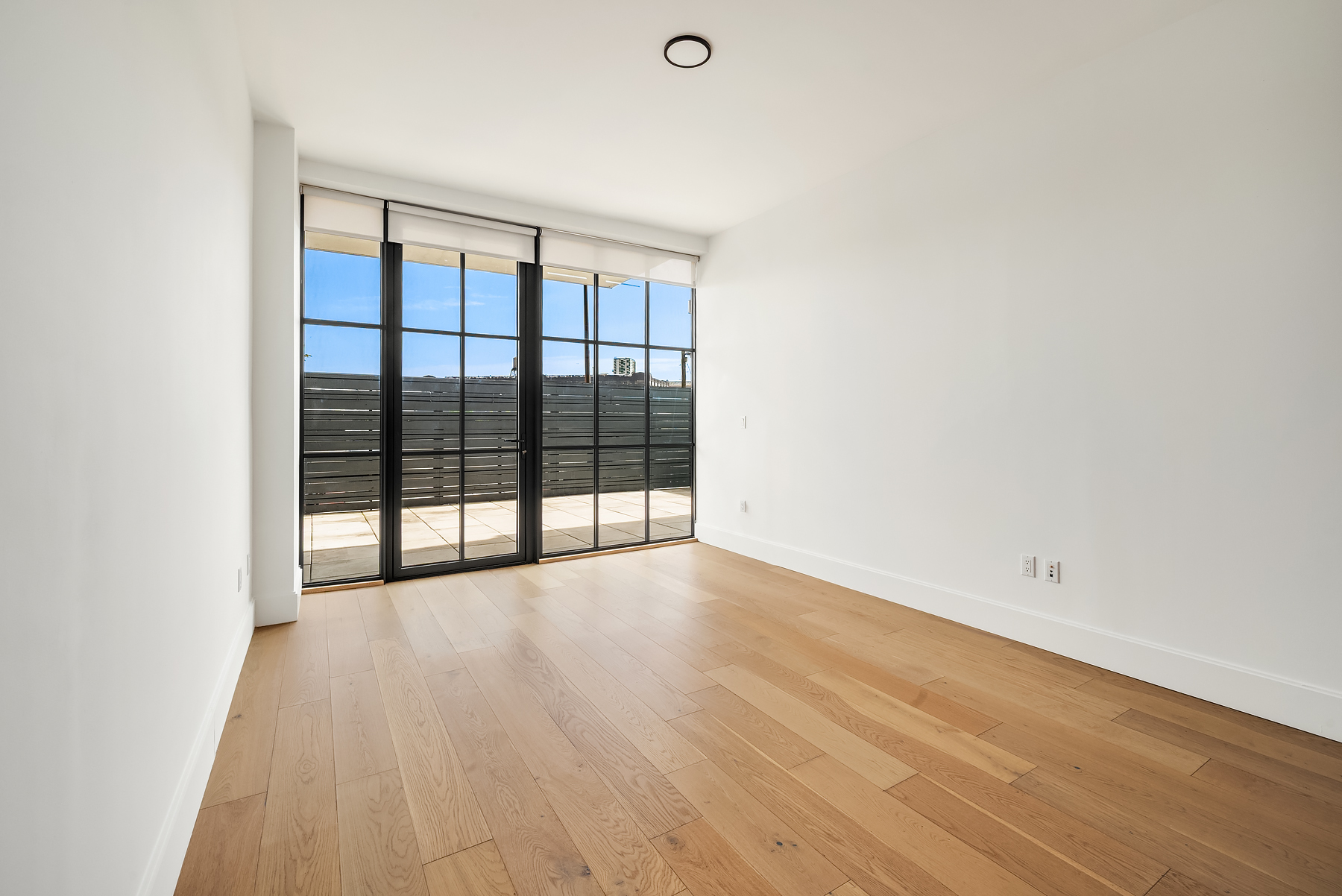 24-22 Jackson Avenue, Unit 311 Queens, NY 11101 - Photo 3 of 16 a view of an empty room with wooden floor and a window