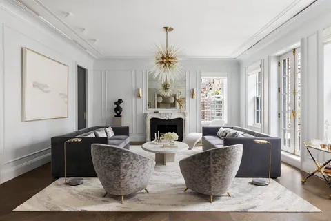 a living room with fireplace furniture and a chandelier