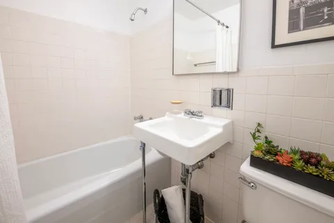 a bathroom with a sink mirror and a bathtub