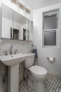 a bathroom with a sink a toilet and mirror