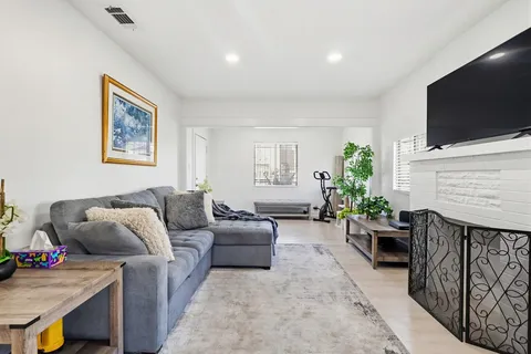 a living room with furniture a flat screen tv and a fireplace