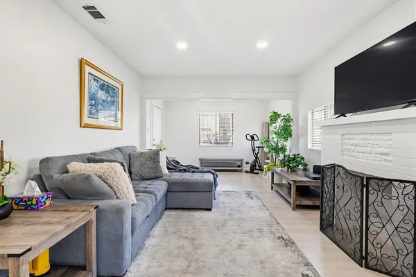 a living room with furniture a flat screen tv and a fireplace