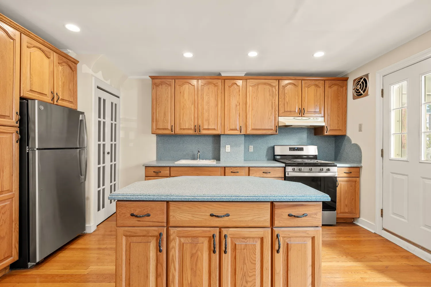 a kitchen with stainless steel appliances granite countertop a refrigerator sink and stove
