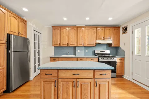 a kitchen with stainless steel appliances granite countertop a refrigerator sink and stove