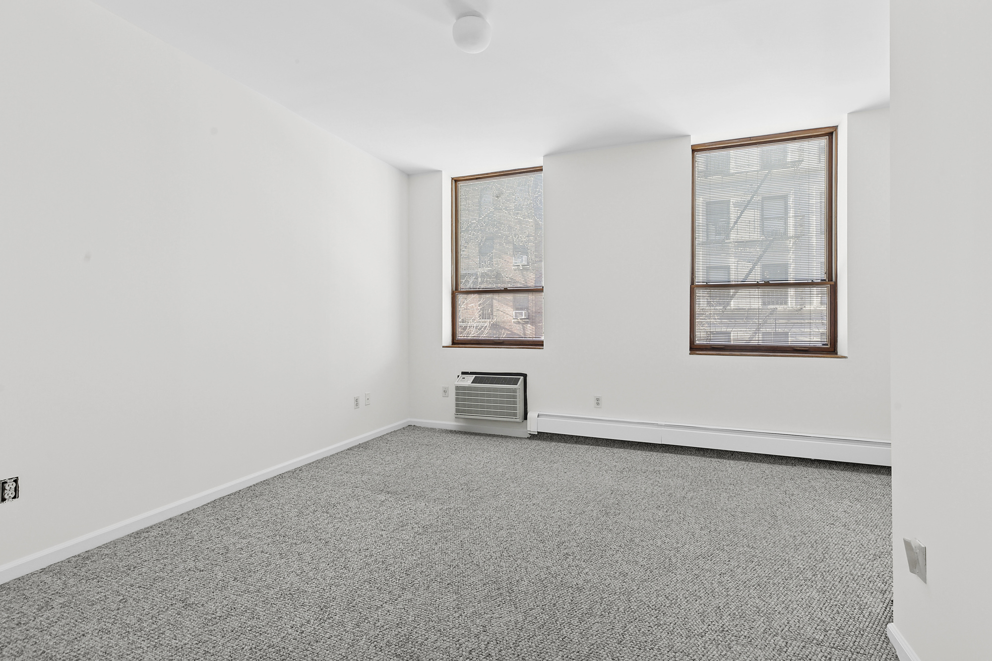 215 West 22nd Street, Unit 2 Manhattan, NY 10011 - Photo 7 of 8 an empty room with windows and cabinet