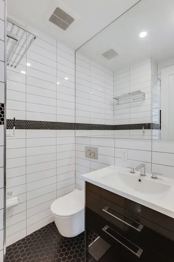a bathroom with a sink mirror and toilet