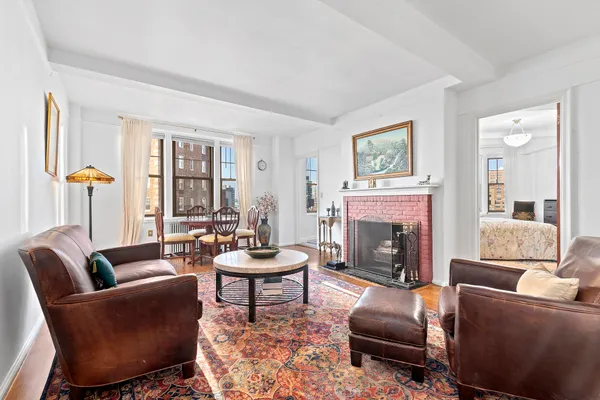 a living room with furniture a fireplace and large windows