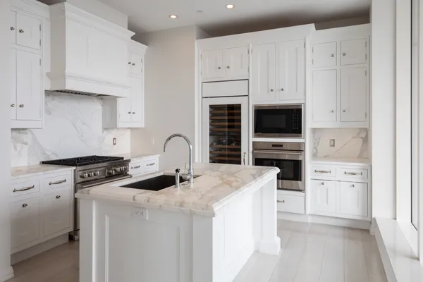 a kitchen with stainless steel appliances granite countertop a stove a sink and a refrigerator