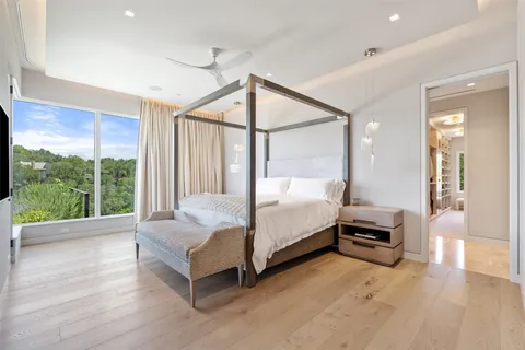 a bedroom with a bed lamp and large window