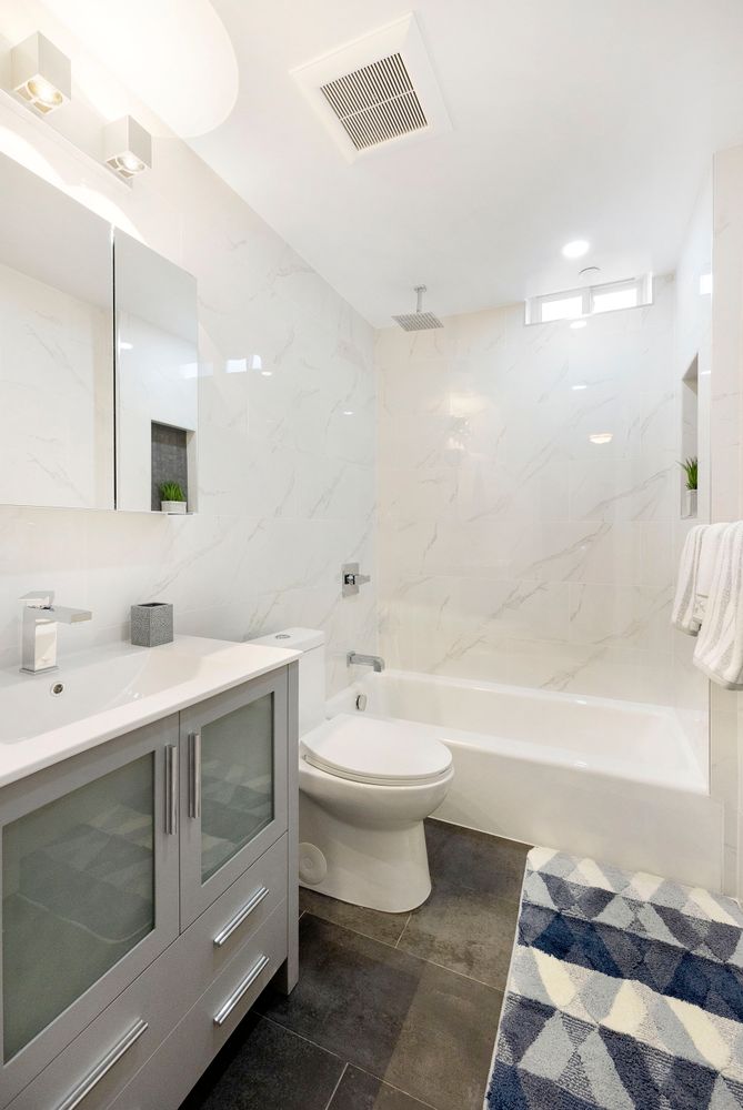 23-05 24th Avenue, Unit PHB Queens, NY 11102 - Photo 5 of 9 a bathroom with a sink a toilet and a bathtub