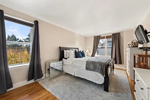 a bedroom with a bed lamps and wooden floor