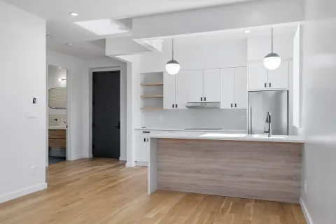 a view of a kitchen with kitchen island a sink stainless steel appliances and cabinets