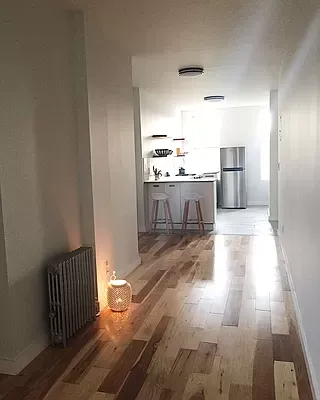 a open kitchen with kitchen island a sink wooden floor and stainless steel appliances