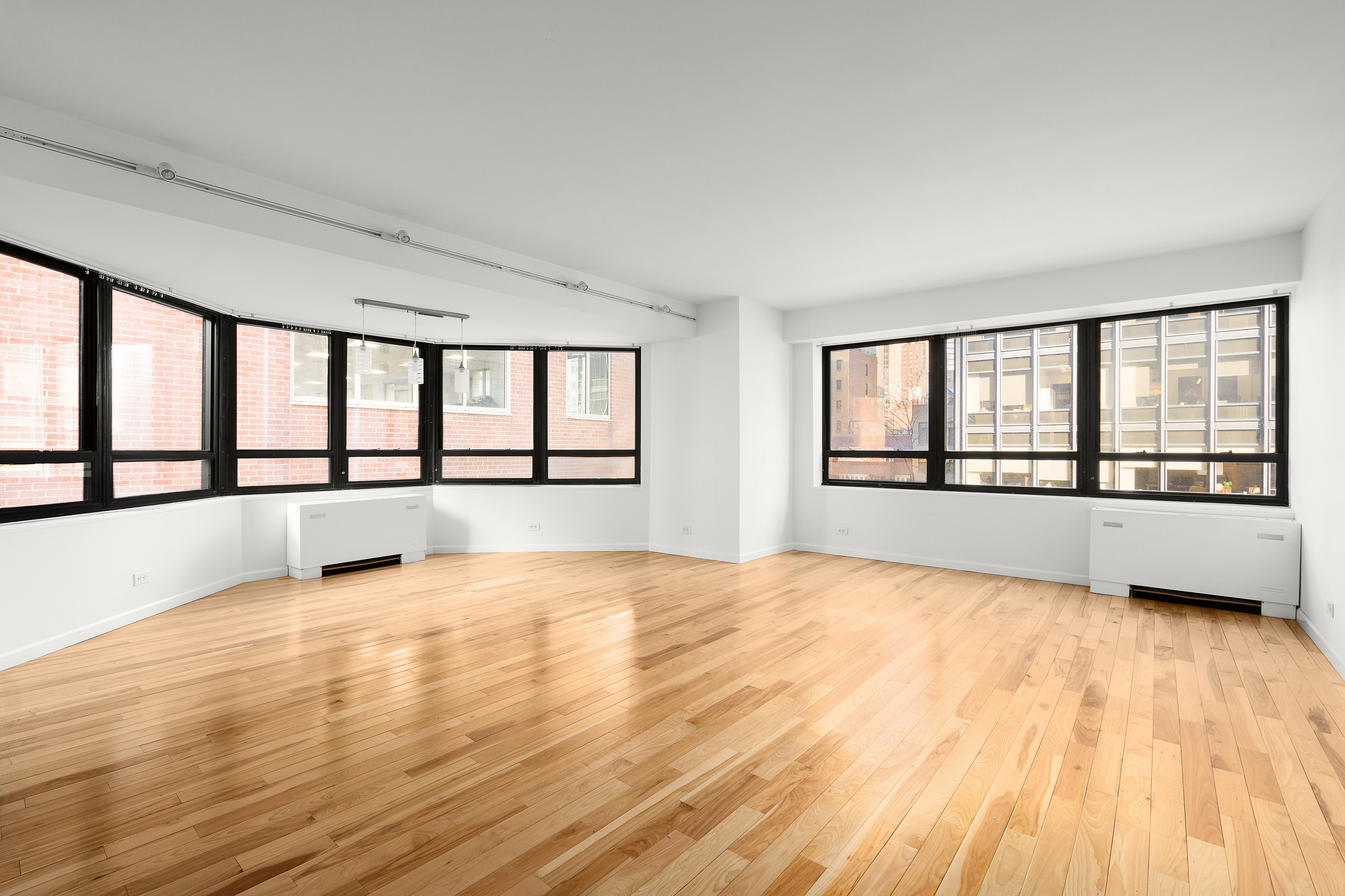 240 East 47th Street, Unit 4B Manhattan, NY 10017 - Photo 2 of 25 a view of an empty room with a window and wooden floor
