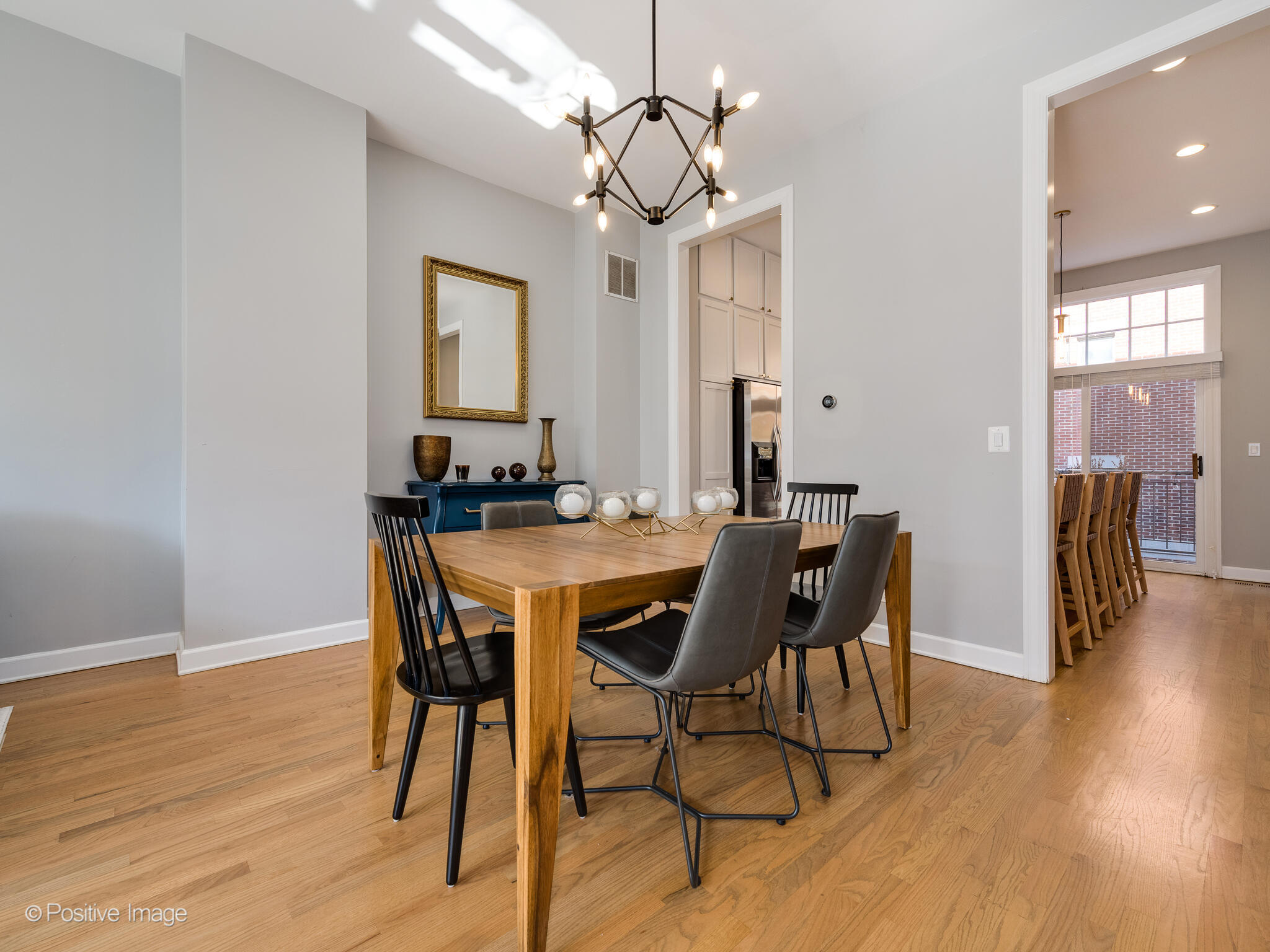 855 North May Street, Unit G Chicago, IL 60642 - Photo 10 of 28 a dining room with wooden floor a chandelier a wooden table and chairs