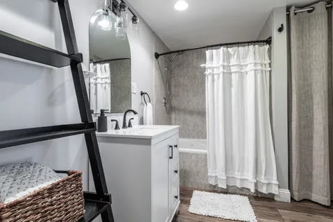 a bathroom with a sink a mirror and a shower